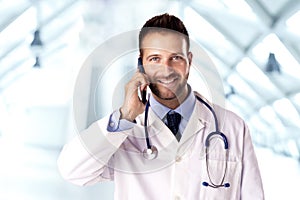 Male doctor talking on cell phone with his patient photo