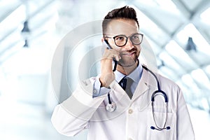 Male doctor talking on cell phone with his patient photo