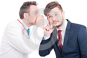 Male doctor telling a secret to curious businessman