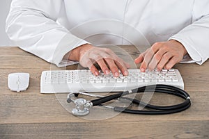 Male Doctor Typing On Computer Keyboard