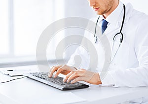 Male doctor typing on the keyboard