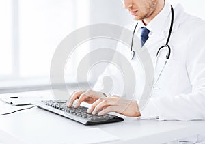 Male doctor typing on the keyboard