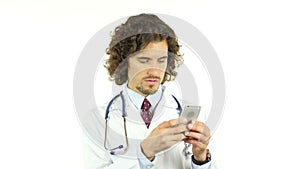 Male doctor typing message on modern smartphone, using smart gadget for work