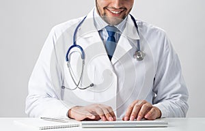 Male doctor typing at wireless computer keyboard