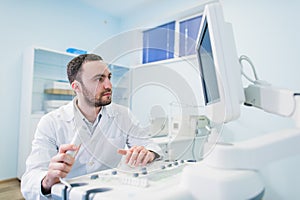 Male doctor with ultrasonic equipment during ultrasound medical examination