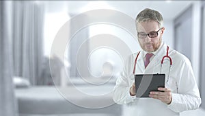 Male doctor uses modern tablet PC in a hospital ward