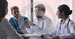Male doctor in white coat lead group meeting with therapists