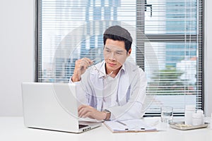 Male doctor working at desk in doctor`s room