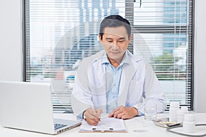 Male doctor working at desk in doctor`s room