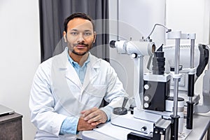 Male doctor working on optometric equipment at clinic