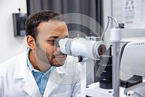 Male doctor working on optometric equipment at clinic