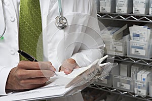 Male Doctor Writing On Clipboard