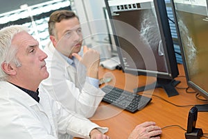 2 male doctors searching tumor on scanner