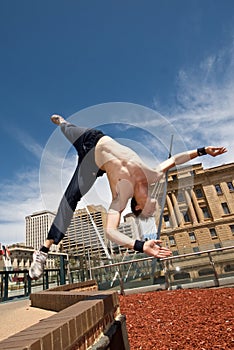 Male doing flip off wall in city