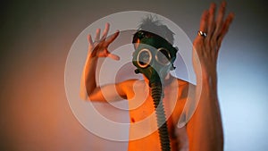 A male dominant in a gas mask dances at a kinky party.