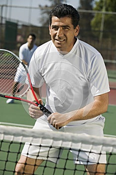 Male doubles tennis players waiting for serve front view focus on foreground