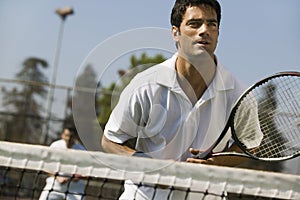 Male doubles tennis players waiting for serve front view focus on foreground