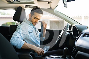 Male driver behind the wheel putting on his seatbelt