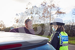 Male Driver Being Stopped By Female Traffic Police Officer For Driving Offence photo