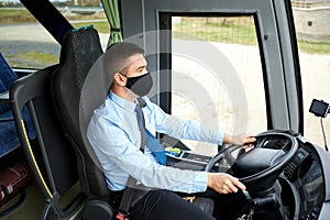 Male driver in black mask driving intercity bus