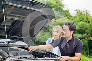 A male driver checks the condition of a car after an accident with an engine
