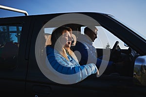 Male driver and female passenger in black car.