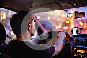 Male driver ride a car during evening traffic jam