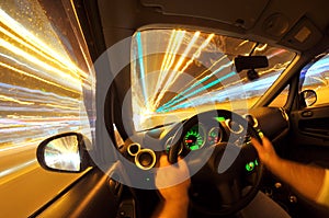 Male driver`s view while driving at night on street lighten up artificially. Fisheye lens and long exposure creates beautiful