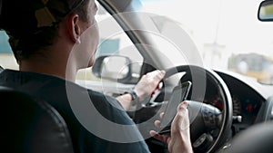 Male driver sitting in the car and holding smartphone with map gps navigation