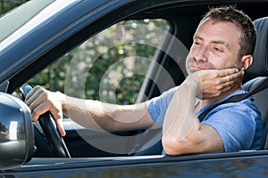 Male driver at wheel sighing in frustration