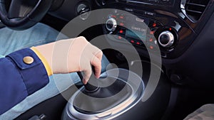 Male driving and changing gear 1 to 2 to 3. A hand of driver man in blue jacket is shifting the manual gear in a car close up.