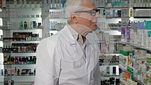 Male druggist wears glasses at the pharmacy