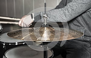 Male drum player hands with sticks playing music on drumkit. Drummer