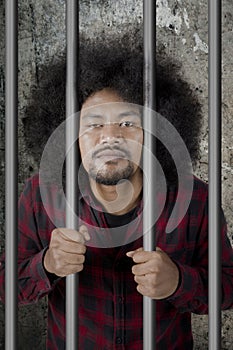 Male drunkard standing in the jail