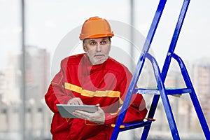 Male elder contruction worker with tablet pc.