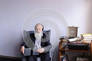 Male Elderly person enjoys listening to rock music on headphones