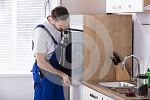 Male Electrician Fixing Oven