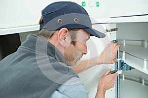 male electrician fixing oven in kitchen