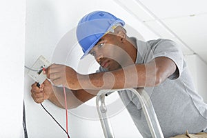 Male electrician wiring switch