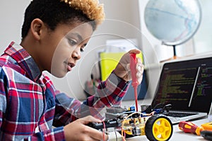 Male Elementary School Pupil Building Robot Car In Science Lesson