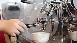 A male employee brews hot coffee for customers.