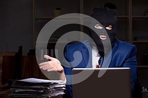 Male employee stealing information in the office night time