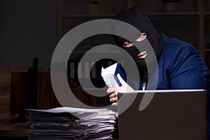 Male employee stealing information in the office night time