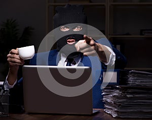 Male employee stealing information in the office night time