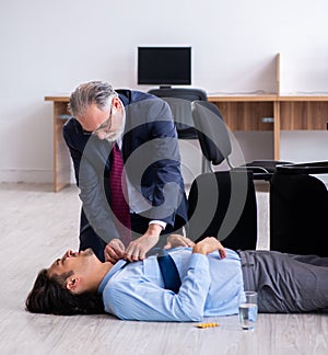 Male employee suffering from heart attack in the office