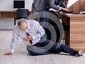 Male employee suffering from heart attack in the office