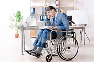 The male employee in wheelchair working at the office