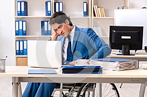 The male employee in wheelchair working at the office