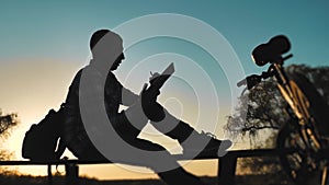 Male employee worker silhouette with digital tablet works lifestyle remotely there is a bicycle nearby. Business concept