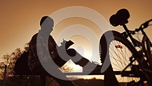 Male employee worker silhouette with digital tablet works remotely there is a bicycle nearby. business concept modern
